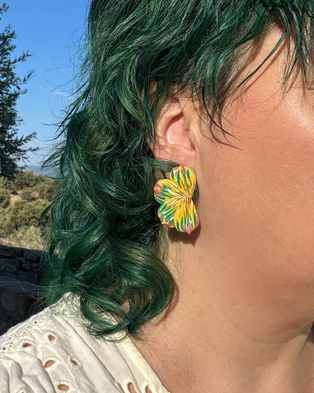 Pendientes Berlanga sobre modelo diseño de media flor en tonos amarillos y verdes