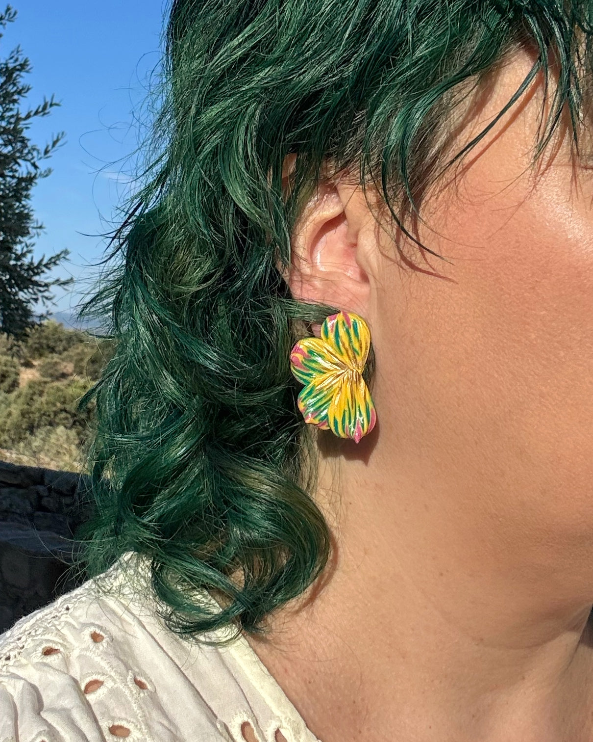 Pendientes Berlanga sobre modelo diseño de media flor en tonos amarillos y verdes