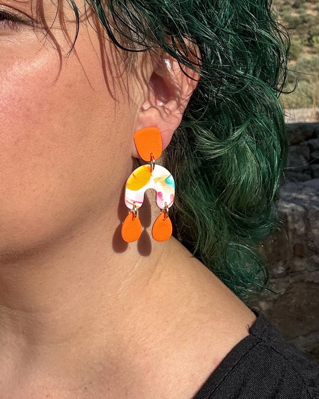 Pendientes Brisa en tonos naranja sobre modelo , con mucho movimiento ligeros y coloridos.
