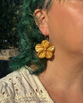 Pendientes Granadilla dorado sobre modelo flor cinco pétalos hechos a mano.