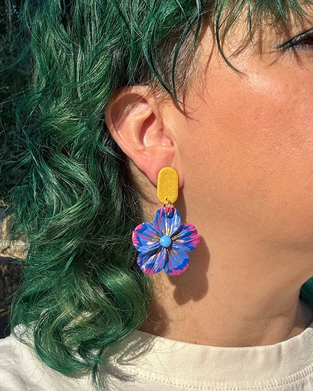 Pendientes Granadilla diseño floral en versión con botón sobre modelo.