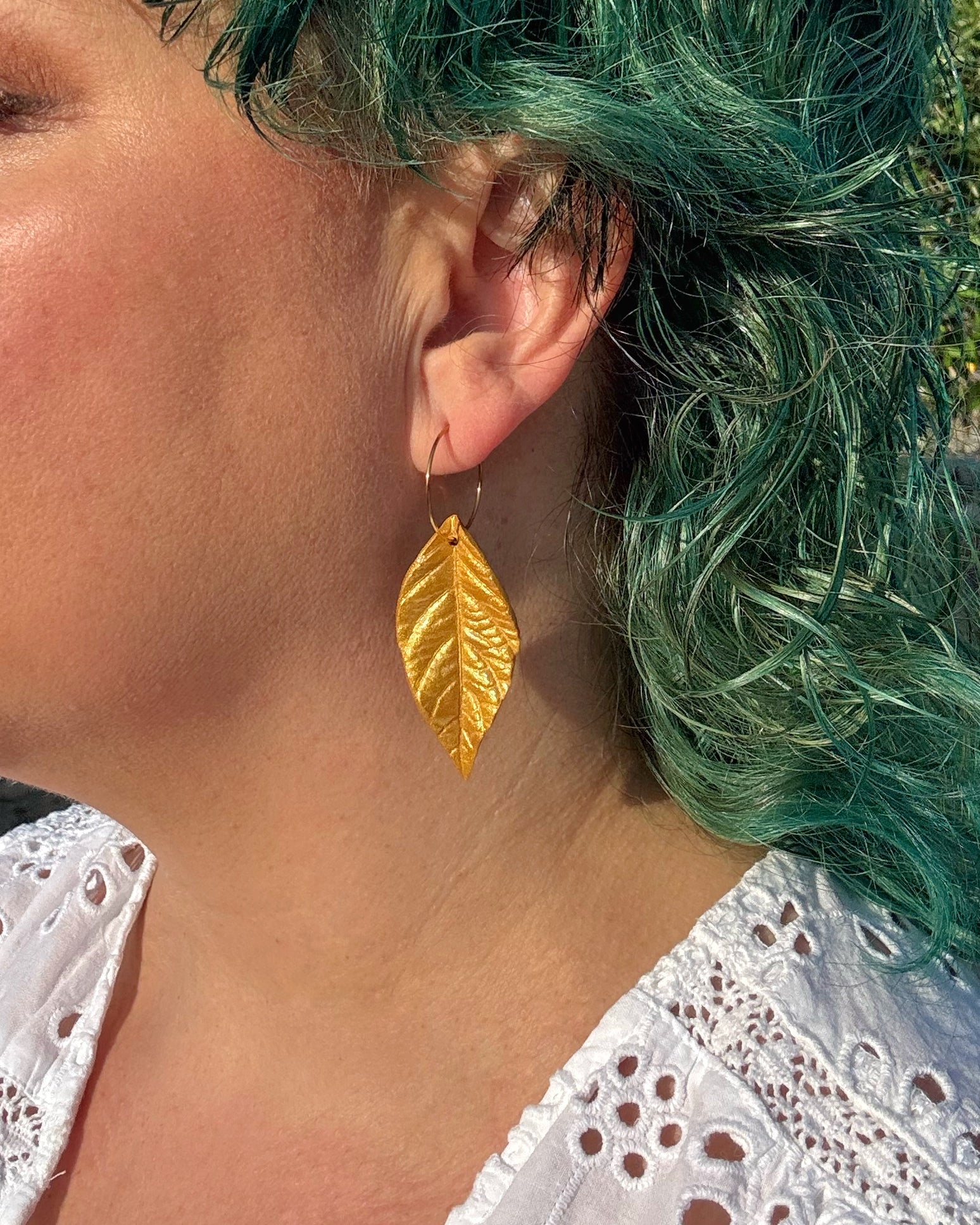 Pendientes hoja dorada sobre modelo muy ligeros y hechos a mano.