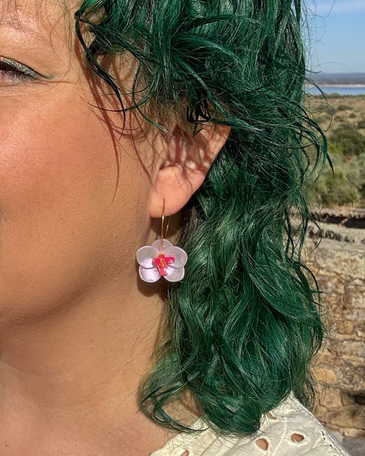 Pendientes Orquídea tornasol sobre modelo lieros y hechos a mano.