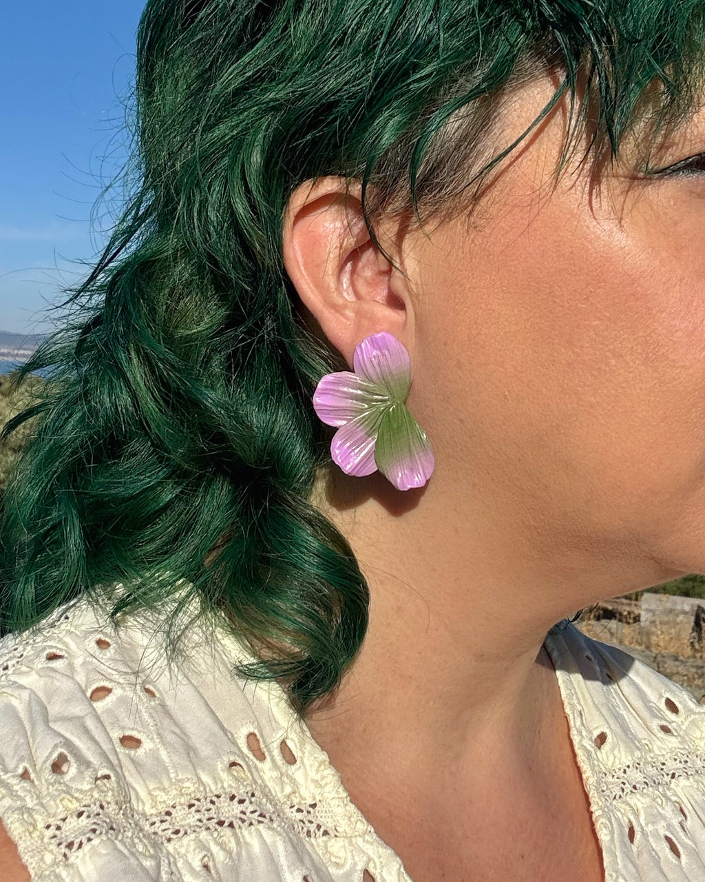 Pendientes Berlanga diseño hecho a mano de media flor en tonos lila y verde sobre modelo